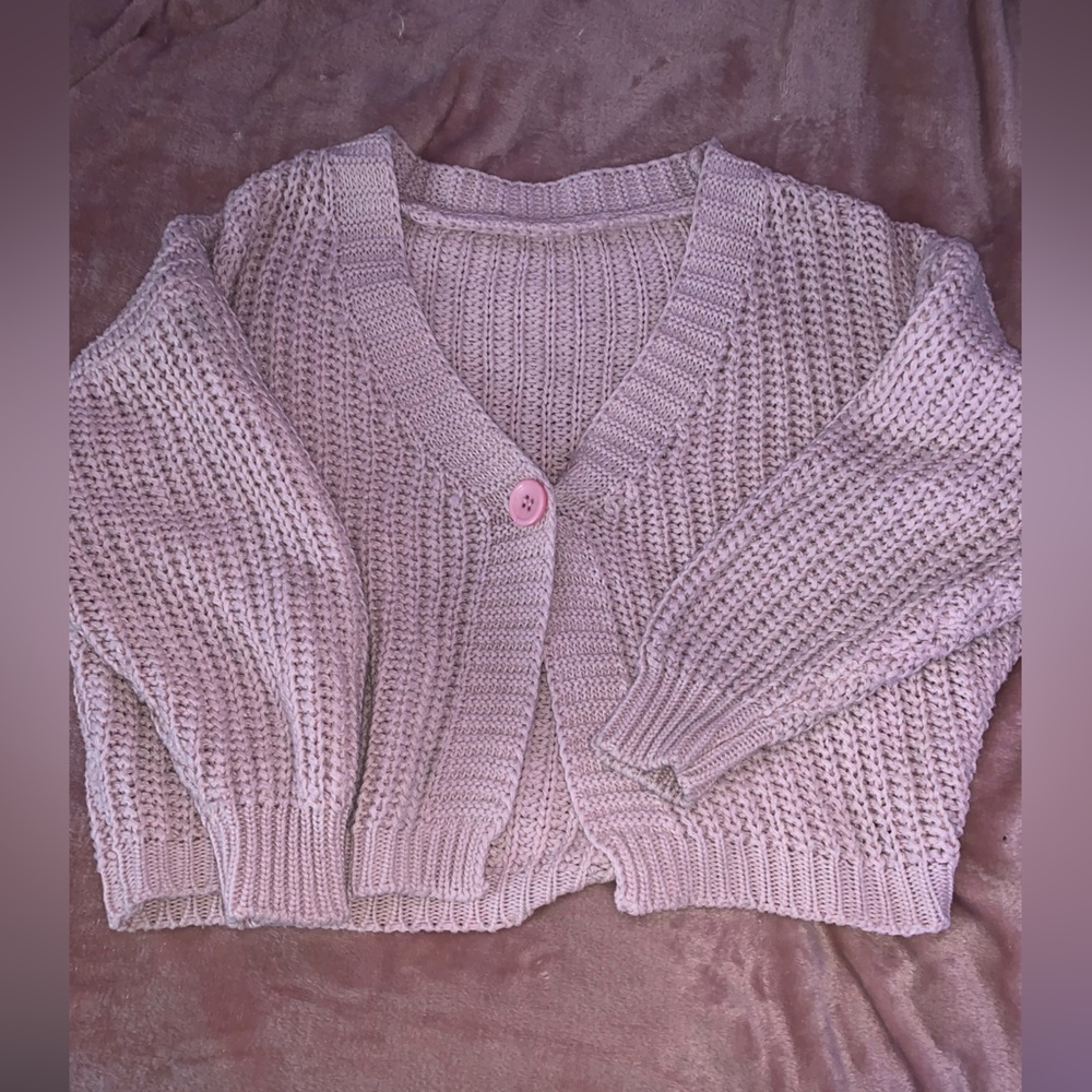 Pink long sleeve cardigan with one button.